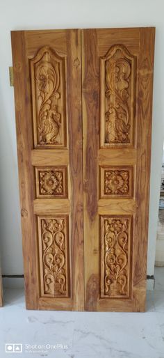 two wooden doors with carved designs on them