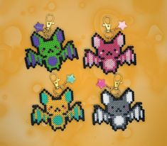 four pixel keychains with different designs and colors are shown on a yellow background