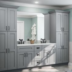 a large bathroom with gray cabinets and marble counter tops