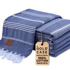 a stack of folded towels with tags on them and the tag says gold case made from 100 % cotton pack of 6