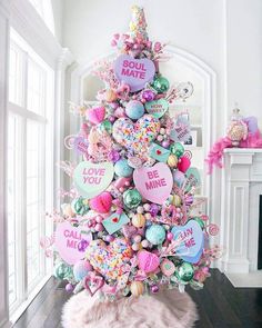 a pink christmas tree with lots of heart decorations