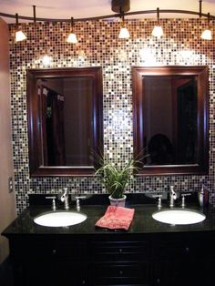 a bathroom with two sinks, mirrors and lights on the wall above them is decorated in mosaic tiles