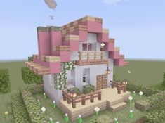 a small pink house in the middle of a field