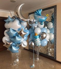 blue and silver balloons in the shape of stars, moon and crescent hanging from a mirror