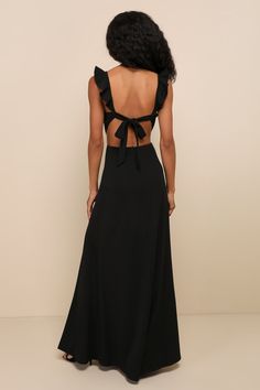 the back of a woman wearing a black dress with a bow at the neckline