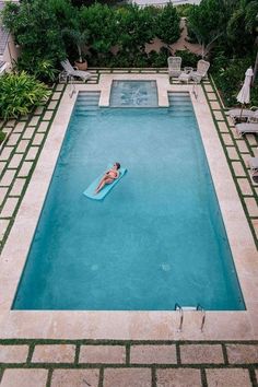 a woman is floating in the pool on an inflatable raft