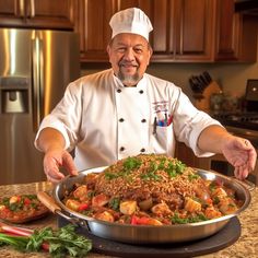 a man in a chef's hat standing next to a large pan of food