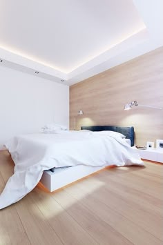 a bed sitting on top of a hard wood floor next to a white headboard