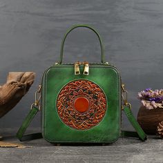 This is a small leather handbags for women with floral totem design. ideal choice as gifts. Features: 100% full grain leather Size: 7.3" x 3.7" x 7.3" Handle length 3.9 inch About 1.84 Ibs Floral totem design in front Two side zipper pockets for daily essentials Durable leather handle Protective feet on bottom Adjustable leather shoulder strap Portable Handheld Leather Box Bag, Portable Green Leather Shoulder Bag, Portable Rectangular Leather Box Bag, Rectangular Hand Tooled Shoulder Bag For Gift, Rectangular Hand Tooled Shoulder Bag Gift, Rectangular Hand-tooled Shoulder Bag Gift, Rectangular Hand Tooled Shoulder Bag, Leather Shoulder Bag As Gift, Green Leather Box Bag For Gift