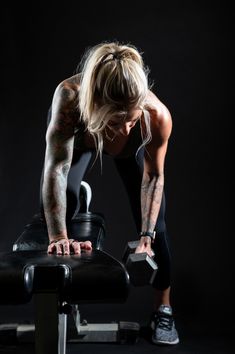 a woman is doing exercises on a bench with dumbbells in front of her