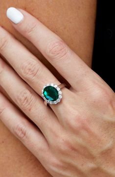 a woman's hand with a ring on her finger and an oval green stone in the middle