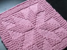 a pink knitted blanket sitting on top of a table