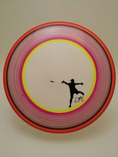 a frisbee with a drawing of a man throwing a frisbee