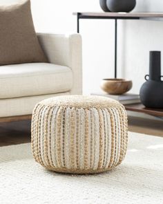 a living room area with a white rug and beige furniture, including a coffee table