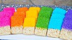 rainbow rice krispy treats are arranged on a white plate