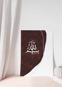 a white vase sitting on top of a table next to a wall with arabic writing