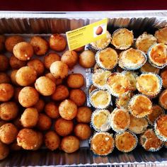 there are many different types of pastries in the trays on display at this market