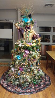 a christmas tree is decorated with colorful ornaments and decorations, including an elaborate headdress