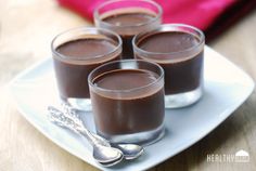 four glasses filled with chocolate pudding on a plate