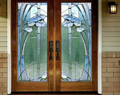 two stained glass doors in front of a house