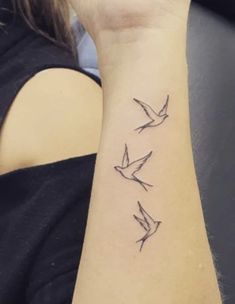 a woman's arm with three birds on it