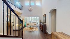 a living room filled with furniture next to a stair case in a white walled house