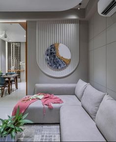 a living room filled with furniture and a circular mirror