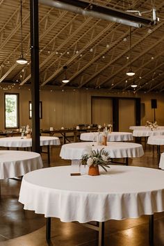 tables with white tablecloths are set up in a large room