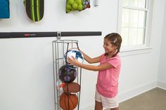 Part of the Rubbermaid FastTrack Garage Organization System, the Rubbermaid Vertical Ball Rack provides secure, space-saving storage for all kinds of sports balls. This ball rack has flexible bungee cord bands that ensure quick, easy access to any ball. It quickly snaps into place on a FastTrack rail and can also be mounted directly to the wall (hardware not included) and holds up to 50-lbs. This ball rack features durable powder-coated steel construction, while a soft grip coating helps prevent Garage Gym Organization, Bungee Cord Storage, Gym Organizer, Garage Organization Systems, Basement Organization, Garage Organize