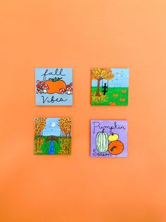 four small magnets on an orange wall with pumpkins and fall scenes painted on them