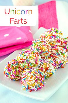 a plate full of sprinkle covered donuts with the words unicorn farts above it