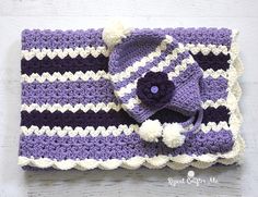 a purple and white crocheted blanket with a hat on top