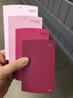 a person holding some pink paint samples in their hand