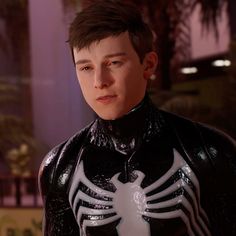 a young man dressed in black and white spider - man costume, looking at the camera