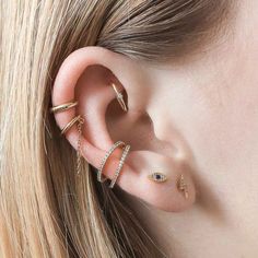 a woman's ear with three different types of piercings