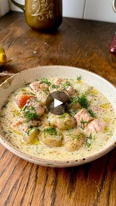 a white bowl filled with soup on top of a wooden table