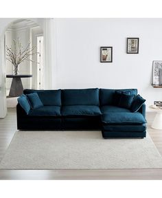 a blue sectional sofa sitting on top of a white rug