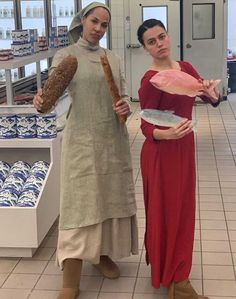 two women standing in a store holding bread