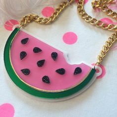 "This is a scrumptious necklace for all seasons! Bring the fun to any outfit with this big and bold watermelon necklace. This original design has been laser cut out of a mix of glitter, mirror, and opaque 1/8\" acrylic sheet and is backed with white, 1/16\" acrylic. The necklace hangs from a thick, gold chain and measures about 16\". We love these necklaces and think that they never get old. However, to prolong the life of yours, treat it with love! Be careful when storing it in a bag or pocket Cute Handmade Plastic Necklace, Cute Party Necklaces For Summer, Cute Summer Party Necklaces, Fun Plastic Jewelry For Party, Green Necklaces For Summer Parties, Fun Plastic Party Jewelry, Trendy Green Necklace For Party, Pink Resin Party Necklaces, Cute Resin Jewelry For Party