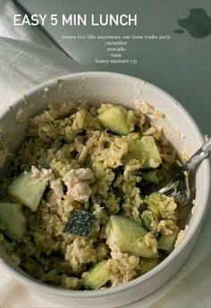 a white bowl filled with rice and cucumbers