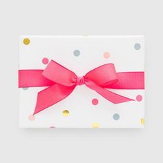 a white box with pink ribbon and polka dots