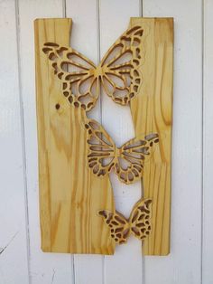 a wooden wall hanging with two butterflies on it