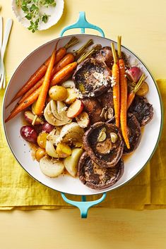 a white plate topped with meat and veggies on top of a yellow table cloth