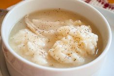 a white bowl filled with mashed potatoes and gravy