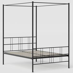 an iron bed frame with four posts and a mattress underneath it, viewed from the side