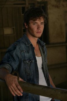 a young man is leaning on a rail in an abandoned building with his hand on the railing