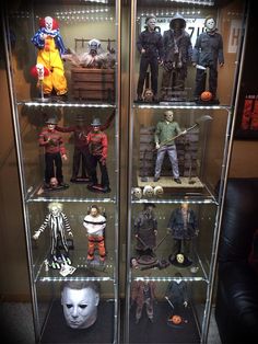 the display case is filled with many different action figures and costumes, including clowns