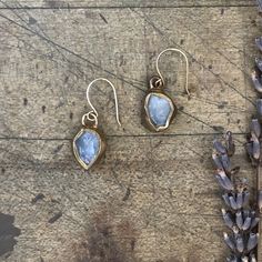 Inspired by a wave crashing where the beach meets the ocean; aquamarine are embedded in brass and dangle from handmade gold-filled earring wires. These earrings sold as a pair of soul mates, not identical twins. Also available in sterling silver. Length 3/4" Width 1/2" This piece is handmade-to-order, please allow 1 - 2 weeks to ship unless this piece is in stock. Each piece will vary slightly due to the uniqueness of the stones. All metal is nickel free. Hand-forged Drop Earrings For Gift, Hand Forged Drop Earrings For Gift, Hammered Teardrop Recycled Gold Jewelry, Gold Moonstone Hand Forged Earrings, Gold Hand Forged Moonstone Earrings, Hand Forged Gold Moonstone Earrings, Hand Forged Teardrop Moonstone Earrings, Delicate Silver Brass Earrings, Hand Forged Moonstone Teardrop Earrings