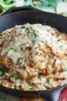 a skillet filled with meat covered in gravy and garnished with parsley