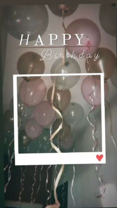 a birthday card with balloons and streamers hanging from the ceiling in front of a wall